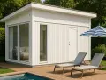 Modernt poolhus med stora fönster och dörr, perfekt för att bygga poolhus. Två solstolar och ett parasoll står på trädäcket.