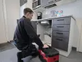 En rörmokare arbetar med en tina frusen vattenledning under diskbänken.