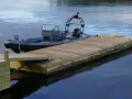 En grå RIB-båt ligger förtöjd vid en nybyggd flytbrygga. Perfekt för att bygga flytbrygga och njuta av vattnet.