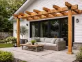 En mysig uteplats med en träpergola, bekväm soffa och ett lågt bord. En vildvin pergola skulle passa perfekt här.
