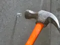 Hammare slår in en plugg i betongvägg. Förberedelse för att skruva i betong.