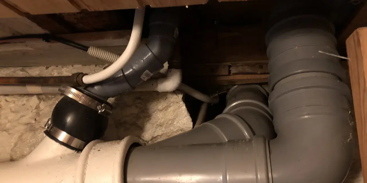 Synligt avloppsrörsystem med böjar och kopplingar, troligen för avluftning toalett.