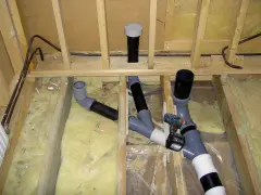 Synlig avloppsinstallation med rör och kopplingar, en del av arbetet med luftning avlopp.