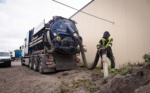 Man använder en sugbil för att tömma en rörledning. Bra sugbil pris kan vara viktigt för projektet.