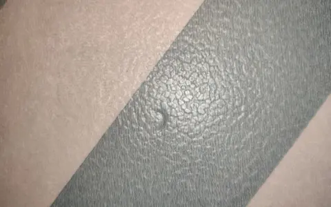 En skadad våtrumsmatta med en liten reva. Dags att laga våtrumsmatta för att förhindra fuktskador.