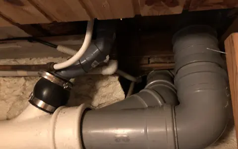 Synligt avloppsrörsystem med böjar och kopplingar, troligen för avluftning toalett.
