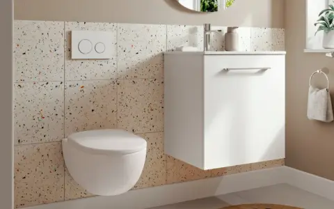 Modernt badrum 3 kvm med vägghängd toalett, vit kommod och kakel med terrazzo-mönster.