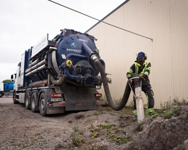 Man använder en sugbil för att tömma en rörledning. Bra sugbil pris kan vara viktigt för projektet.