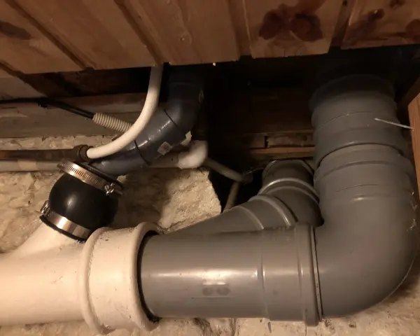 Synligt avloppsrörsystem med böjar och kopplingar, troligen för avluftning toalett.