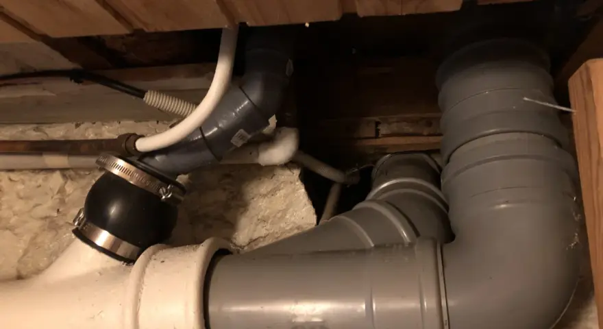Synligt avloppsrörsystem med böjar och kopplingar, troligen för avluftning toalett.
