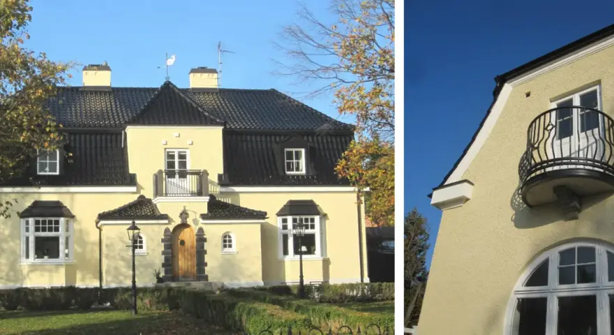 Gult hus med spritputsad fasad, svart tak, balkong och vackra fönster.