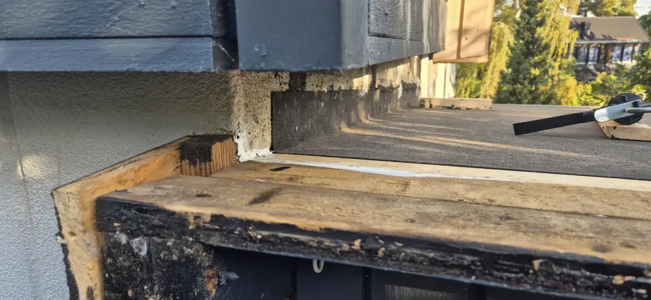 Detaljbild av en papptak konstruktion med trädetaljer och takpapp. Verktyg ligger på taket.